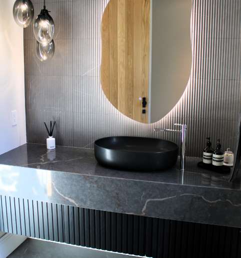 Luxury black slatted bathroom storage units crafted by a high-end cabinet manufacturer.