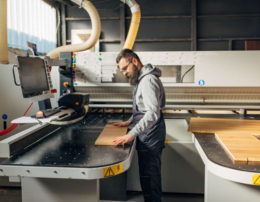 Expert woodworker using high-tech equipment for precision cabinet manufacturing at Koka Cabinets in Ontario.