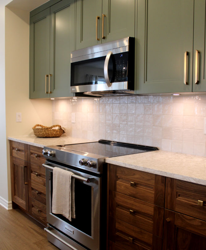 Modern two-tone custom kitchen cabinets in olive green and walnut with elegant gold hardware.